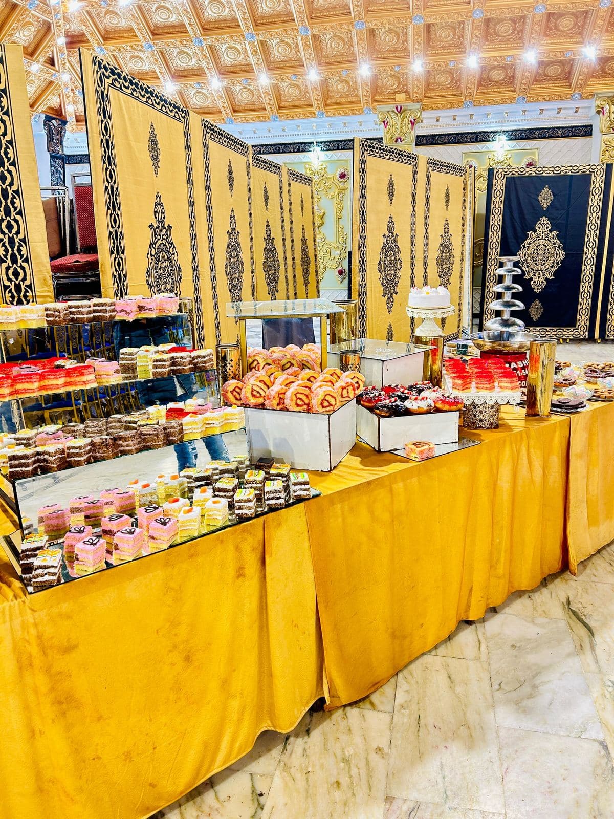 Traditional Dessert Buffet — Tiered counters with traditional Pakistani sweets and desserts.