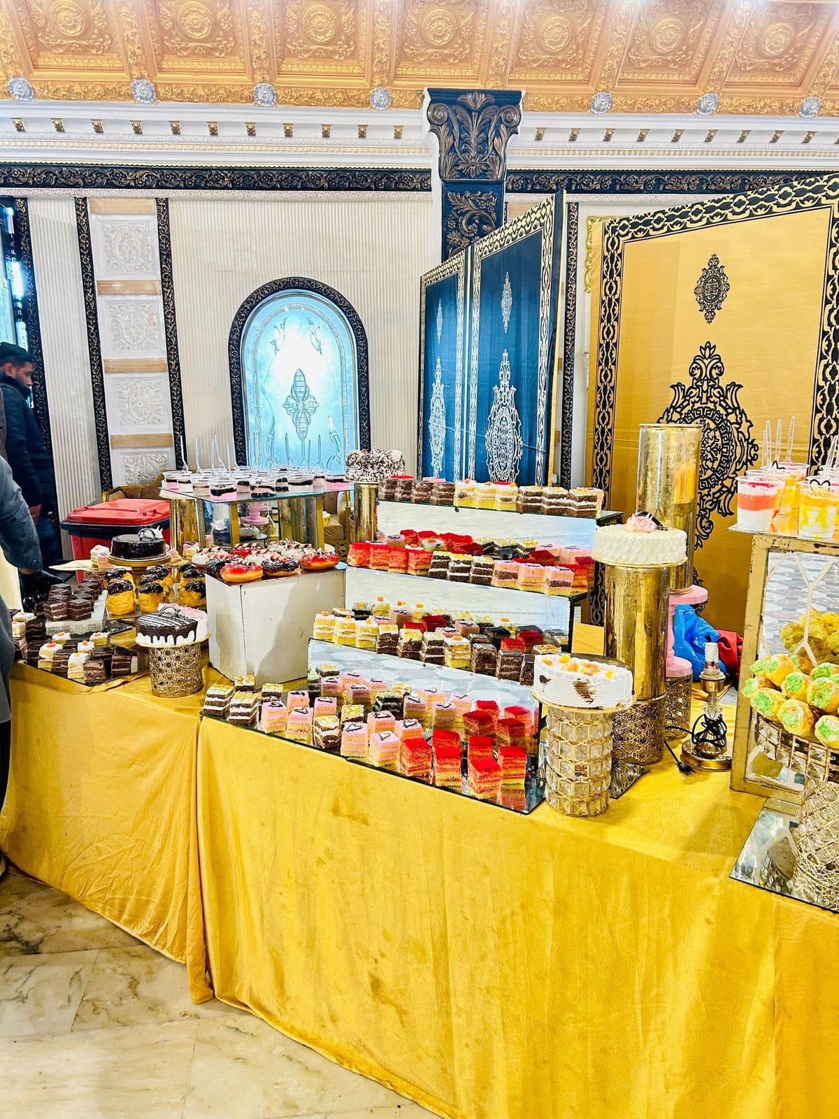 Dessert Presentation Counter — Gold-trimmed buffet counter presenting confections and fresh fruits.