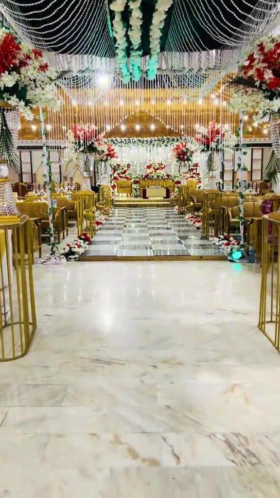 Central Carpeted Aisle — Wide central procession aisle framed by table arrangements.